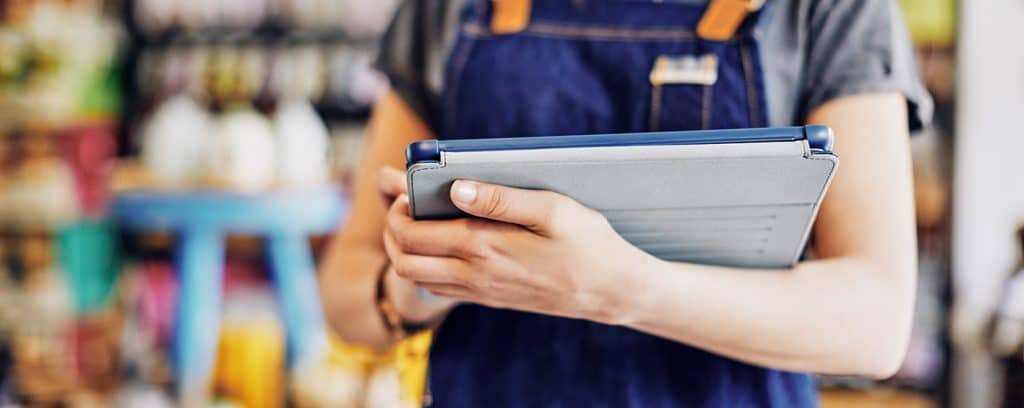 Lagermitarbeiterin die mittels mobiler App und Tablet die Inventur erledigt