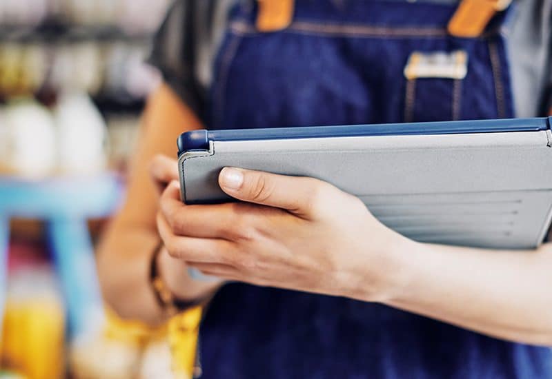 Lagermitarbeiterin die mittels mobiler App und Tablet die Inventur erledigt